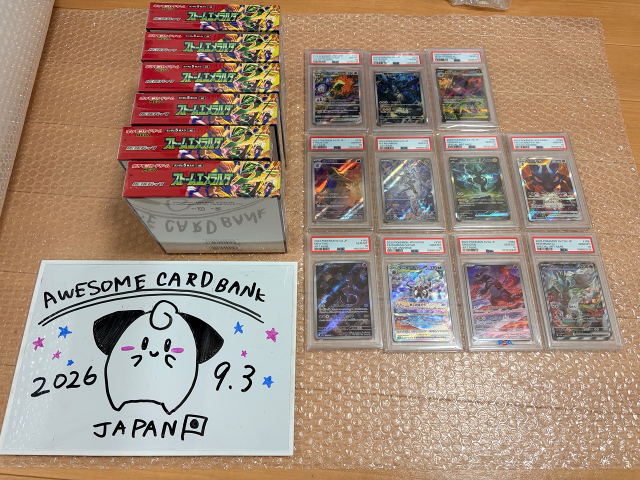 Sealed boxes stay in their shrink wrap; graded cards are checked and lined up before they go into the carton.
